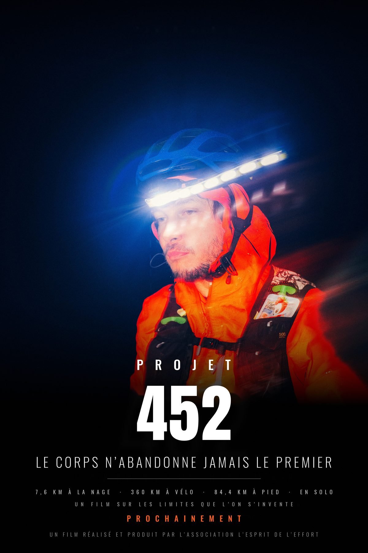 Affiche du film Projet 452 : portrait de nuit de l'athlète, lampe frontale allumée. 7,6 km à la nage, 360 km à vélo, 84,4 km à pied, en solo.